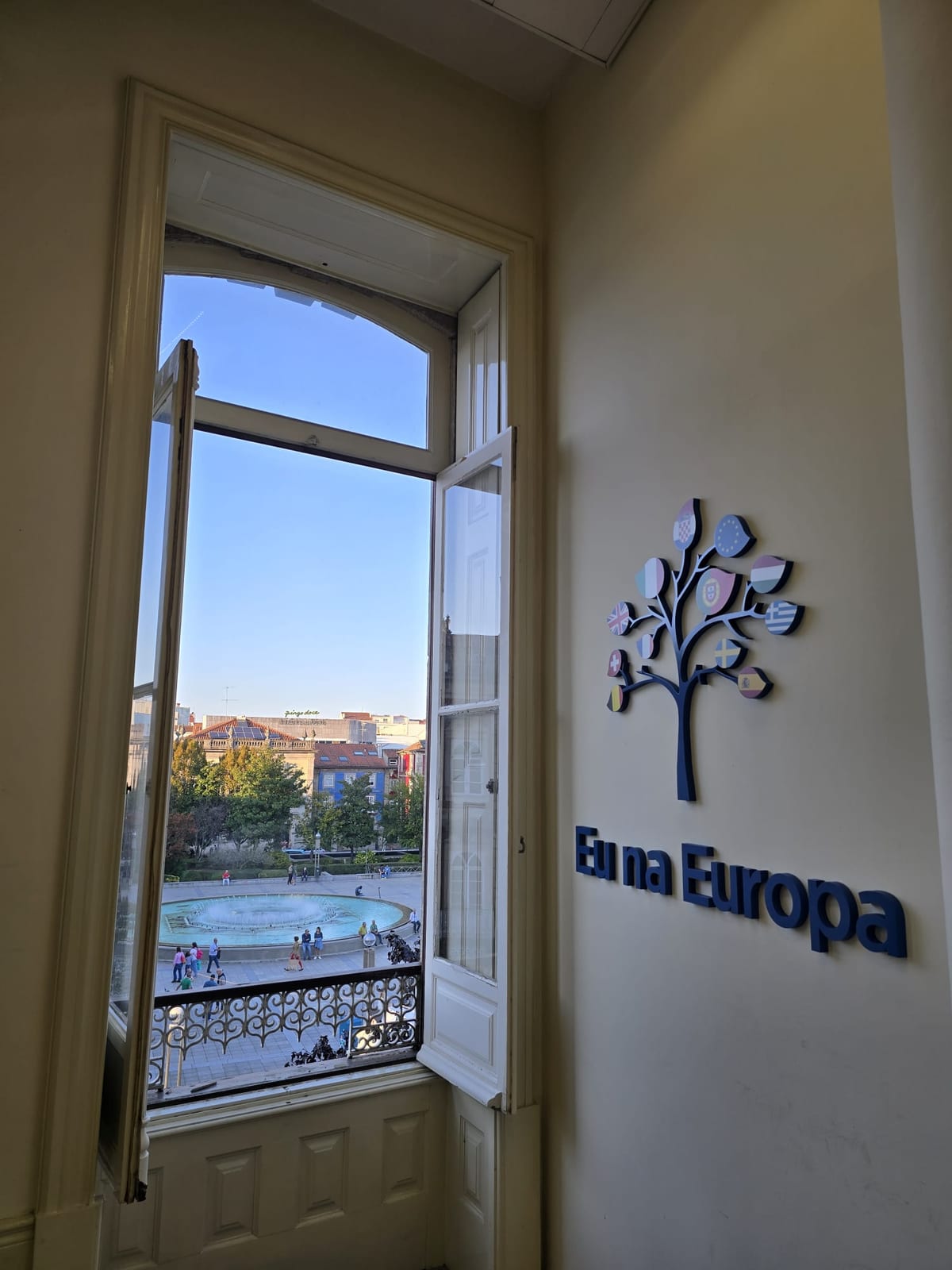 Vista da janela do escritório da Eu na Europa em Braga, Portugal, com a logo na parede